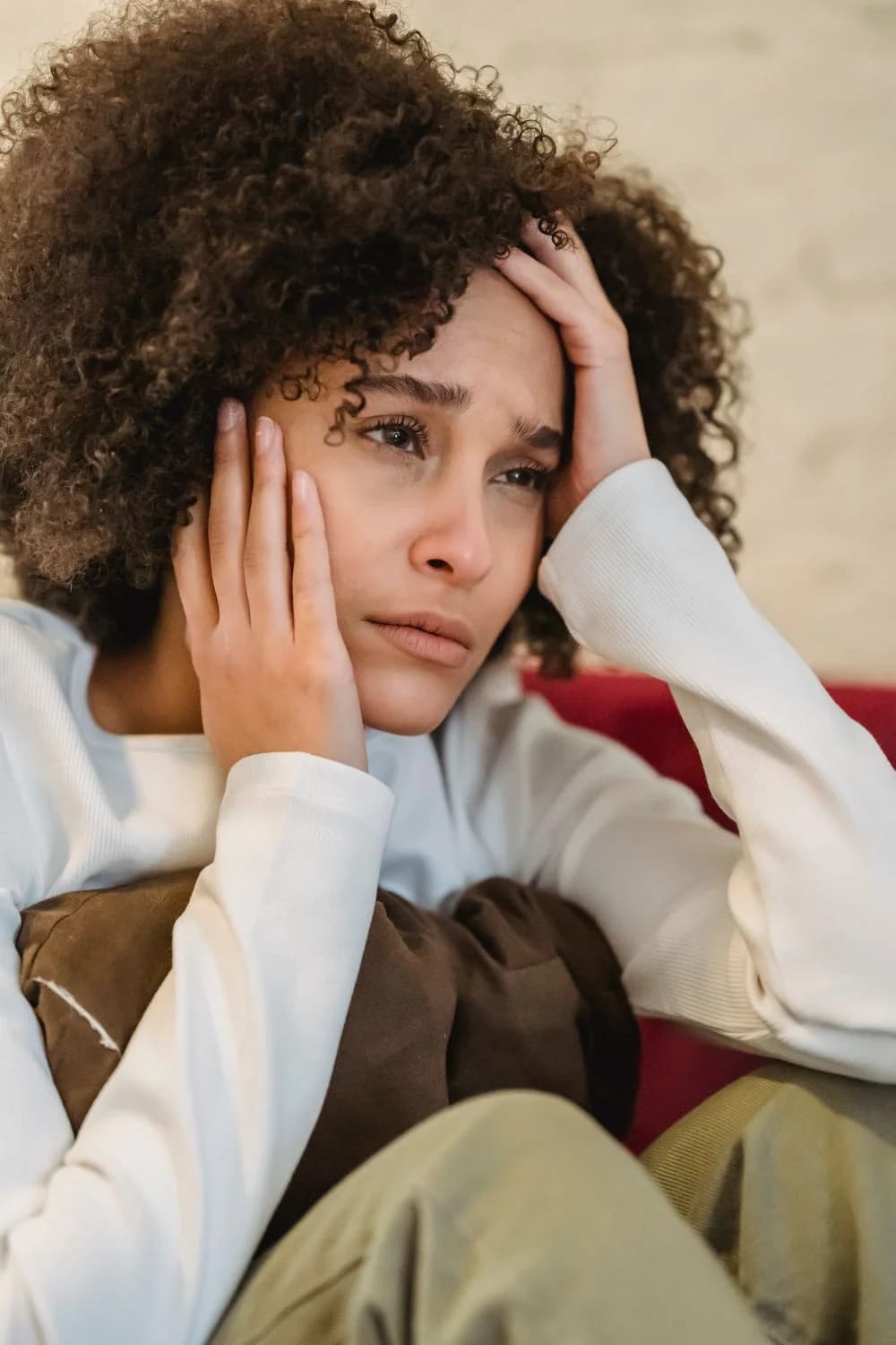 A disappointed woman sitting on a sofa at home, illustrating changed plans and an unused ticket